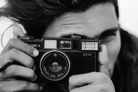 Brand Analysis - Black and White Photo of Man with Analog Camera