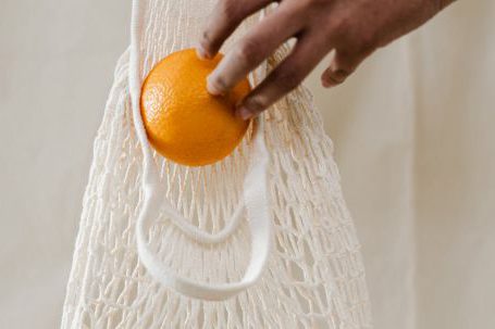 Fresh Groceries - Person Holding Orange Fruits in White Net