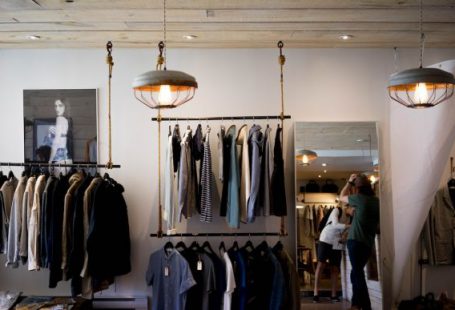 Luxury Clothing - person leaning on wall while holding gray hat