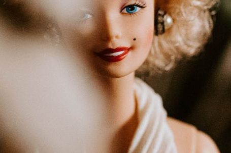 Avoiding Fakes - Smiling doll with blond curly hairstyle wearing elegant white decollete dress for wedding