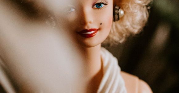 Avoiding Fakes - Smiling doll with blond curly hairstyle wearing elegant white decollete dress for wedding
