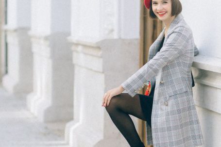 French Elegance - Woman in Plaid Blazer Standing Against a Wall